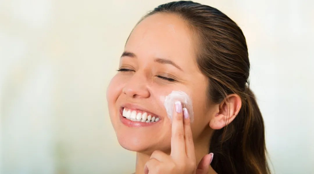 wanita memakai sunscreen gel yang tidak lengket di wajah