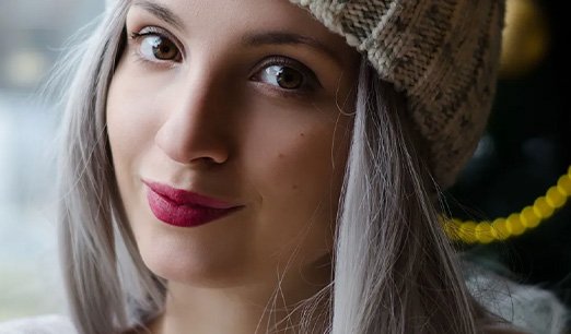 Wanita rambut ash grey dengan makeup bold lips sebagai fokus